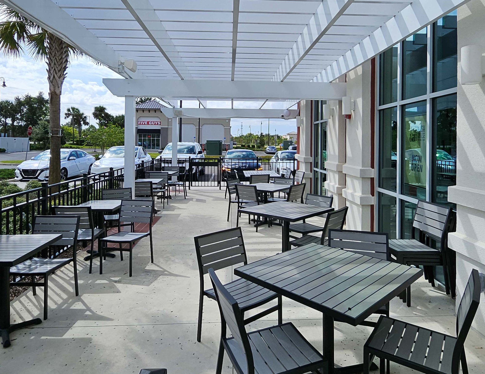outside seating area with black chairs and a white awning